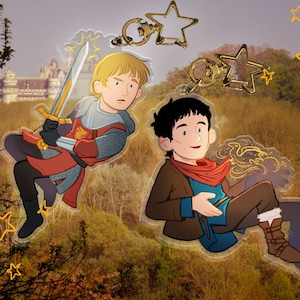 May include: Two cartoon characters, one in a red and gold knight costume holding a sword and the other in a brown jacket and blue shirt, are depicted as charms with gold star accents.