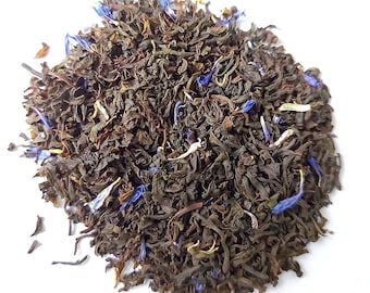 May include: A close-up of a pile of loose leaf black tea with blue cornflower petals.