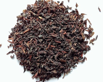 May include: Loose black tea leaves, dried and ready for brewing. The tea leaves are a dark brown color and have a slightly reddish hue.