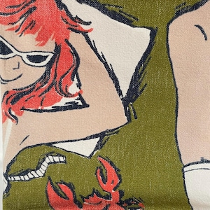 Könnte beinhalten: Ein grüner Stoff mit einer rothaarigen Frau, die eine Sonnenbrille und ein weißes Hemd trägt. Ein roter Hummer befindet sich in der unteren Ecke des Stoffes.
