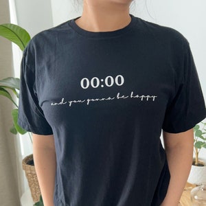 May include: Black t-shirt with white text that reads "00:00 and you gonna be happy".
