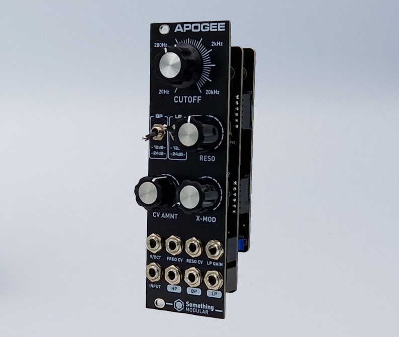 Pu&ograve; includere: Un modulo sintetizzatore nero con il nome "APOGEE" stampato sul davanti. Ha manopole per cutoff, reso, quantit&agrave; di CV e X-mod. Ha jack per V/Oct, Freq CV, Reso CV, LP Gain e input. Ha anche jack HP e LP.