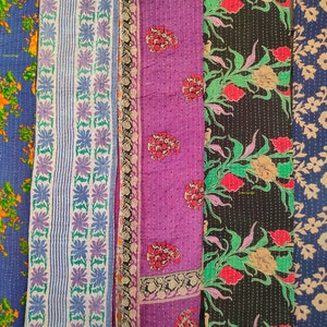 Peut inclure: Cinq panneaux de tissu avec des motifs floraux. Les panneaux sont dans des tons de bleu, blanc, violet, noir et vert. Le tissu est matelass&eacute; et a un aspect vintage.