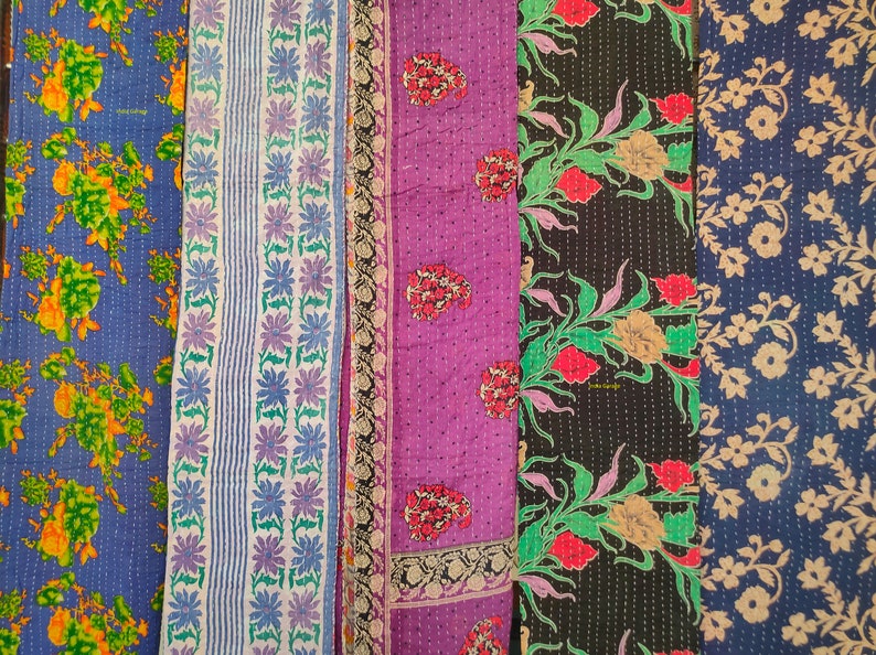 Peut inclure: Cinq panneaux de tissu avec des motifs floraux. Les panneaux sont dans des tons de bleu, blanc, violet, noir et vert. Le tissu est matelass&eacute; et a un aspect vintage.