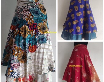 Pode incluir: Três estilos diferentes de saias de enrolar. A primeira saia é branca com um padrão floral multicolorido. A segunda saia é azul com um padrão de pavão dourado. A terceira saia é vermelha com um padrão floral dourado. As três saias são feitas de seda e têm um design fluido e em camadas.