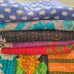 Peut inclure: Une pile de six quilts kantha de diff&eacute;rentes couleurs et motifs, notamment bleu, turquoise, noir, violet, rouge et orange. Les quilts sont en coton et pr&eacute;sentent un motif cousu &agrave; la main. Le texte "India Garage" est visible sur le quilt du bas.