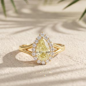 IGI-gecertificeerde verlovingsring met 2 karaat fancy gele peervormige laboratoriumdiamant en halo-zetting, en een gespleten ringband van 14 karaat geelgoud.