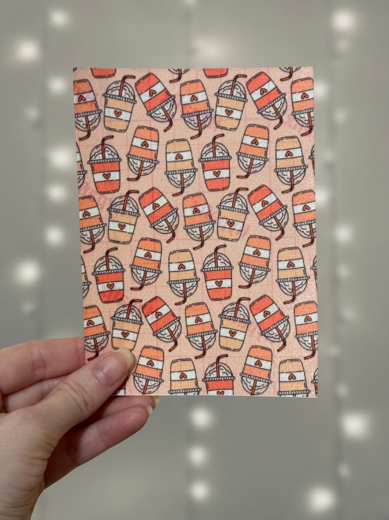 Puede incluir: Una tela de color rosa y naranja con un dise&ntilde;o repetido de tazas de caf&eacute; con corazones y pajitas.