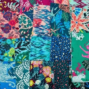 May include: A collection of fabric swatches with various floral, animal print, and abstract designs. The color palette includes shades of teal, pink, blue, and green. Some swatches feature large floral patterns, while others have leopard spots or tropical leaves.