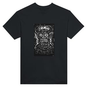 Könnte beinhalten: Schwarzes T-Shirt mit einem weißen Grafikdruck eines gehörnten Dämons mit grimmigem Gesichtsausdruck. Die Illustration im Holzstichstil zeigt das Gesicht, die Hörner und den Bart des Dämons. Das T-Shirt hat einen Rundhalsausschnitt.