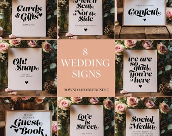 May include: Eight wedding signs with black text on white cards. The signs feature phrases such as "Cards & Gifts," "Pick a Seat," and "Guest Book." The signs are displayed with floral decorations.