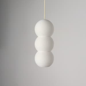 May include: A hanging pendant light fitting featuring three stacked matte white spheres in a vertical column. The light is suspended by a thin, light-coloured cord attached to the top sphere, creating a clean, geometric, and linear silhouette.