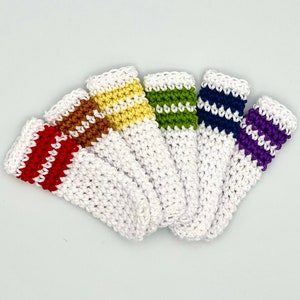 May include: Six crocheted fingertip covers in white with colorful stripes. The colors are red, orange, yellow, green, blue, and purple.