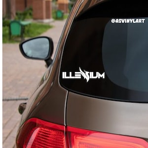 May include: White vinyl decal with the word "ILLENIUM" and a stylized bird design. The decal is on the back window of a brown car. The social media handle "@ASVINYLART" is visible in the upper right corner of the image.