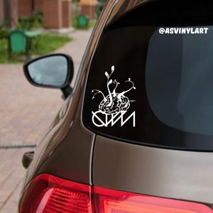 May include: White vinyl decal of a brain with vines growing out of it, with the text "QWM" below. The decal is on the back window of a car. The decal is for sale on Etsy. @asvinylart