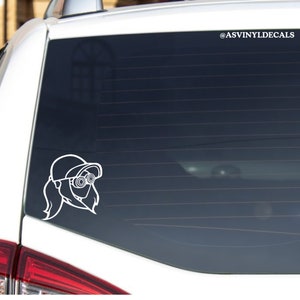 May include: White vinyl decal of a cartoon character with a cap and goggles on a car window. The decal is on a black background. The text "@ASVINYLDECALS" is in the top right corner of the image.