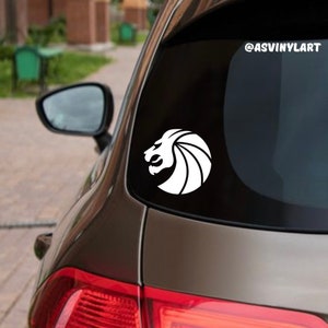 May include: A white vinyl decal of a lion's head with a mane, on a brown car. The decal is on the back window of the car. The text "@ASVINYLART" is in the top right corner of the image.