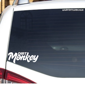 May include: White vinyl decal with the text "DIRT MONKEY" in a stylized font on a white car.