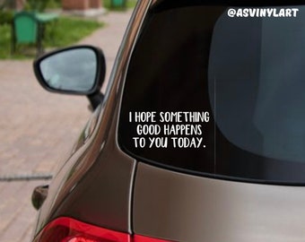 May include: A black car with a white vinyl sticker on the back window that says "I hope something good happens to you today." The sticker is on a black background and has a white border.