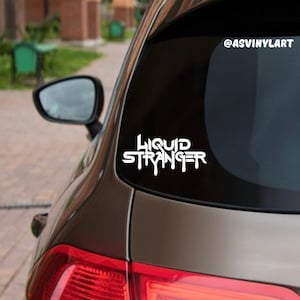 May include: A white vinyl sticker with the text "LIQUID STRANGER" in a dripping font style, applied to the back window of a brown car. The sticker is on a black background.
