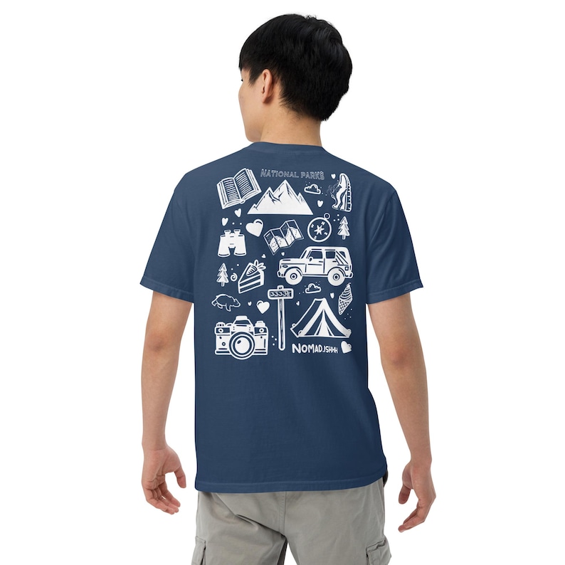 May include: Navy blue t-shirt with a white graphic design featuring camping and outdoor adventure icons, including mountains, a tent, a camera, and the text "NATIONAL PARKS" and "NOMAD1544".