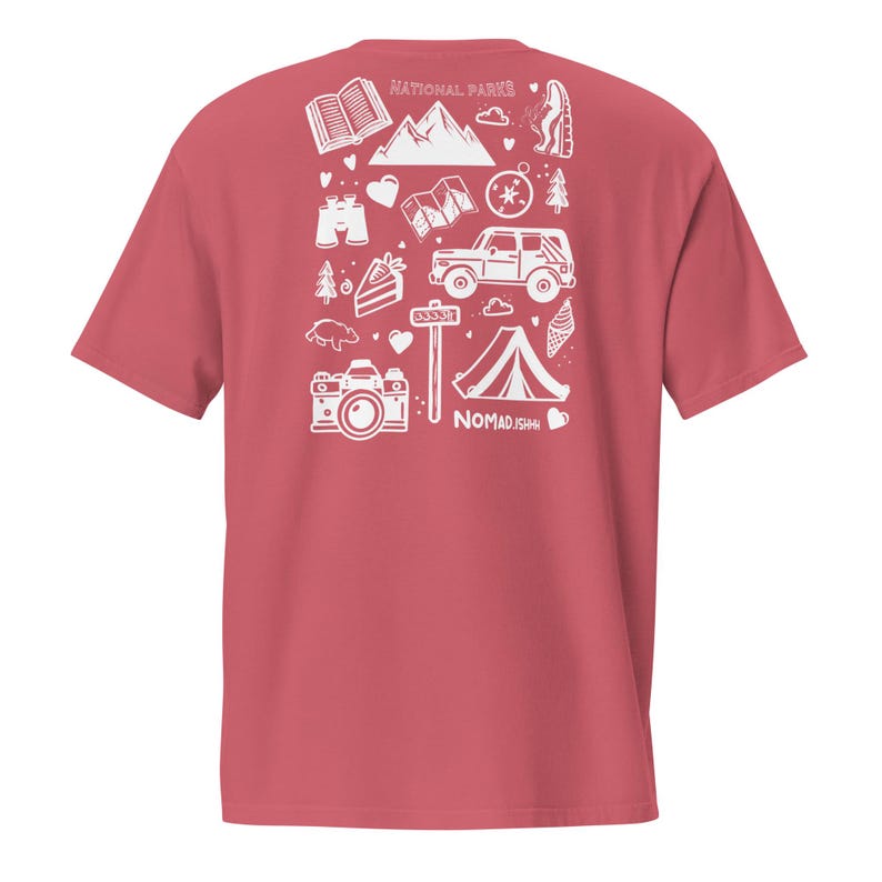 May include: A red t-shirt with a white graphic design featuring camping and outdoor adventure icons. The design includes mountains, a tent, a camera, and the text "NATIONAL PARKS" and "NOMAD.ISH".