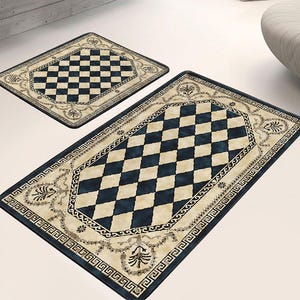 May include: Two black and white checkered patterned bath mats with a beige border and intricate floral designs. The mats are on a white surface.