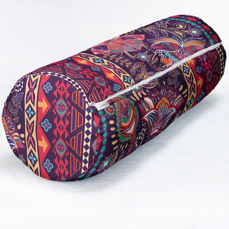 May include: A cylindrical bolster pillow featuring a dark purple base with a vibrant, multi-colored pattern of paisley, floral motifs, and geometric shapes in shades of red, yellow, orange, and teal, complete with a white zipper along the side.