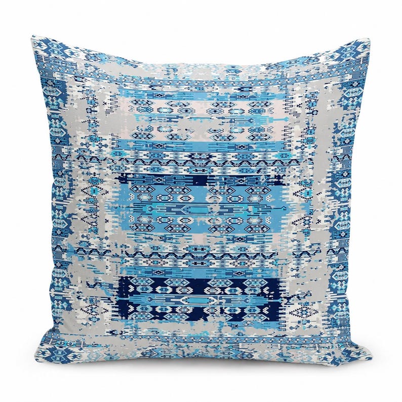 May include: A square throw pillow featuring a repeating geometric pattern in shades of navy blue, light blue, and white. The design includes horizontal bands of intricate shapes and distressed textures on a light gray background.