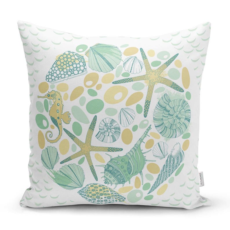 Peut inclure: Un coussin blanc avec un motif vert et jaune repr&eacute;sentant une vari&eacute;t&eacute; de coquillages, d'&eacute;toiles de mer et d'hippocampes. Le motif est en forme de cercle et est entour&eacute; d'un motif de vagues.