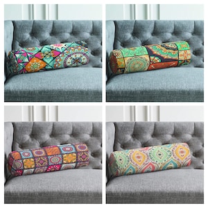 Può includere: Quattro cuscini cilindrici con diversi motivi su divani grigi. I cuscini hanno una varietà di colori e motivi, tra cui verde, blu, arancione, rosa e giallo.