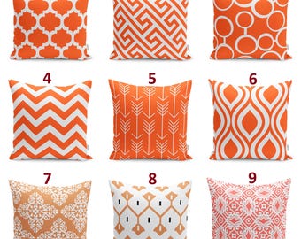Op de afbeelding: Een collectie van negen vierkante sierkussens met diverse witte geometrische patronen op een oranje achtergrond, waaronder vierpas-, Griekse sleutel-, cirkel-, chevron-, pijl-, ogee-, damast- en abstracte motieven, genummerd van één tot negen.