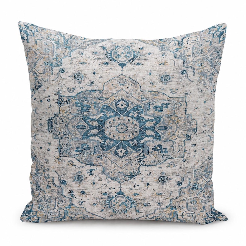 May include: A square throw pillow featuring a detailed, symmetrical medallion pattern in shades of deep blue, light blue, and beige. The design incorporates intricate floral and geometric motifs across the entire surface of the fabric.