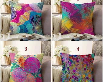 May include: Four square throw pillows featuring vibrant abstract patterns. Pillow 1 has blue and pink petal shapes. Pillow 2 displays multi-colored brushstrokes. Pillow 3 shows circular motifs in pink and orange. Pillow 4 features a colorful marbled design.