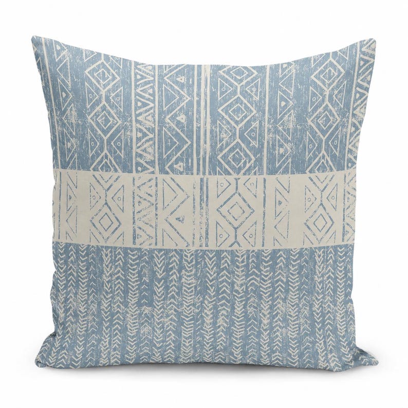 May include: A square throw pillow featuring a dusty blue and off-white color scheme. The design consists of horizontal bands displaying geometric patterns, including diamonds, triangles, and vertical chevron-like lines with a distressed texture.