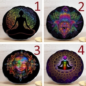 May include: A set of four round decorative pillows featuring black backgrounds with vibrant, multi-colored graphic prints. Designs include a silhouette in a lotus position, a hamsa hand, a Buddha face, and a meditating figure with chakra points.