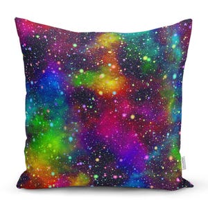 May include: A colourful throw pillow with a galaxy print. The pillow features a dark blue background with swirling clouds of pink, purple, green, and yellow. The print is reminiscent of a starry night sky.
