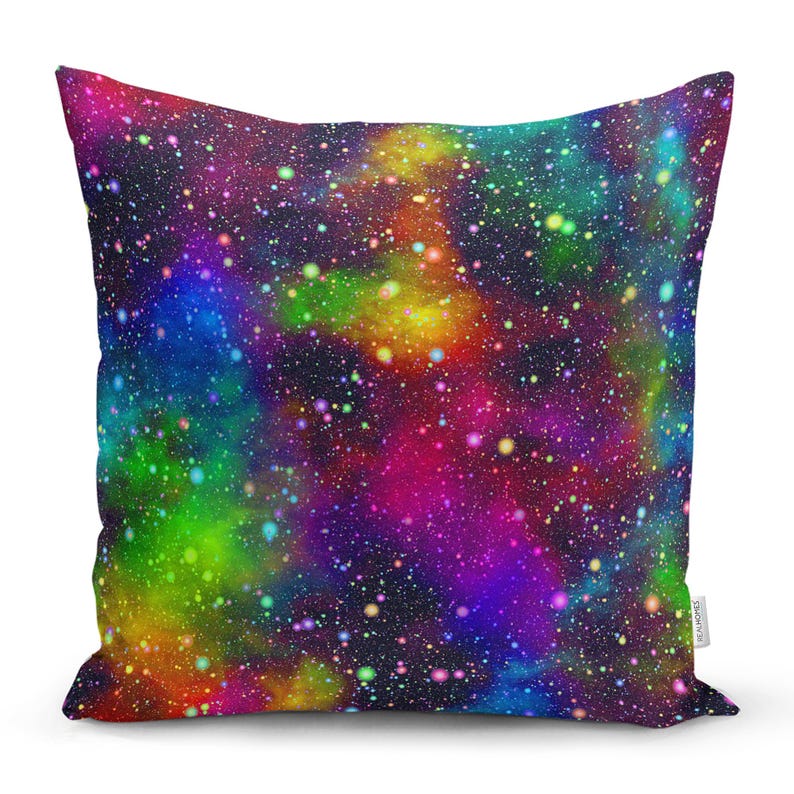 May include: A colourful throw pillow with a galaxy print. The pillow features a dark blue background with swirling clouds of pink, purple, green, and yellow. The print is reminiscent of a starry night sky.
