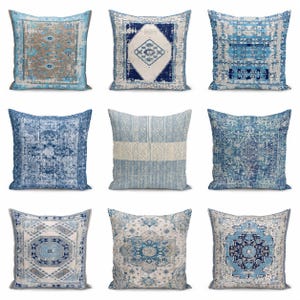 May include: A collection of nine square throw pillows featuring various blue, white, and beige patterns. The designs include intricate geometric shapes, distressed rug-inspired motifs, and symmetrical floral-like medallions on each pillow cover.