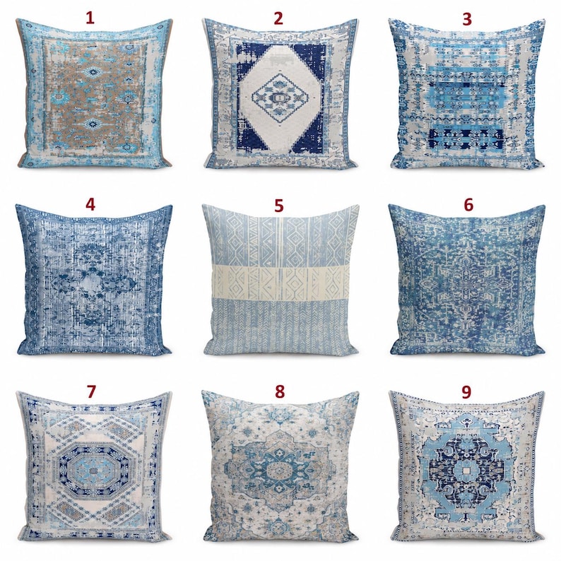 May include: A collection of nine square throw pillows featuring various blue, white, and beige patterns. Each pillow displays distinct geometric, floral, or medallion designs with a distressed, weathered texture across the fabric surfaces.