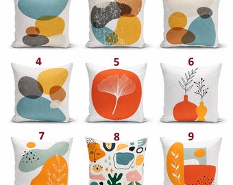 May include: A collection of nine square throw pillows featuring various abstract designs, including organic shapes, ginkgo leaves, vases with botanical line art, and colorful patterns in shades of orange, blue, yellow, gray, and white.