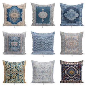 Può includere: Una collezione di nove cuscini quadrati con diversi motivi blu, beige e multicolori. Ogni cuscino presenta intricati disegni geometrici, floreali o a medaglione stampati sul tessuto, disposti in una griglia di tre per tre.