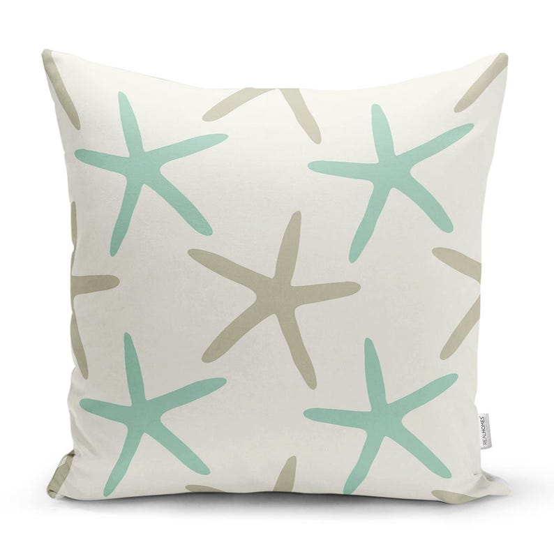 Peut inclure: Un coussin blanc avec un motif d'&eacute;toiles de mer brun clair et turquoise. Le coussin est fait d'un tissu doux et confortable et est parfait pour ajouter une touche de style c&ocirc;tier &agrave; votre maison.