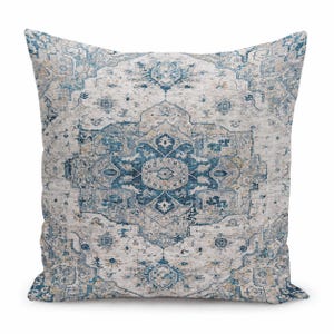 May include: A square throw pillow featuring a detailed, symmetrical medallion pattern in shades of deep blue, light blue, and beige. The design incorporates intricate floral and geometric motifs across the entire surface of the fabric.