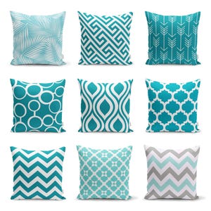 Può includere: Nove fodere per cuscini decorative con vari motivi geometrici in tonalità di turchese e bianco. I motivi includono frecce, cerchi, zigzag e altro ancora.