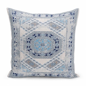 May include: A square throw pillow featuring a central octagonal medallion pattern in shades of navy blue, light blue, and white. The design includes intricate geometric and floral motifs with a distressed, weathered texture throughout the fabric.