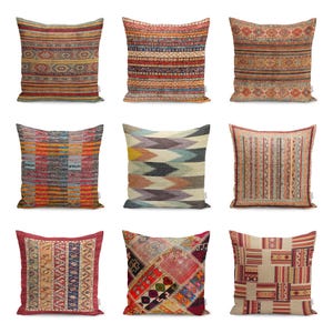 Könnte beinhalten: Neun dekorative Kissen mit verschiedenen bunten geometrischen Mustern. Die Kissen sind aus einem weichen, gewebten Stoff gefertigt und in verschiedenen Farben gehalten, darunter Rot, Orange, Gelb, Grün, Blau und Braun.