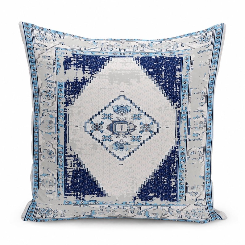 May include: A square throw pillow featuring a distressed, vintage-inspired pattern in shades of navy blue, light blue, and white. The design includes a central diamond motif surrounded by intricate geometric borders and floral accents.