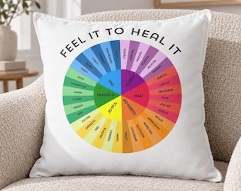 May include: A white square throw pillow featuring a colorful circular emotion wheel graphic. The text FEEL IT TO HEAL IT is printed in black in an arc above the wheel, which displays various emotions categorized by color segments.