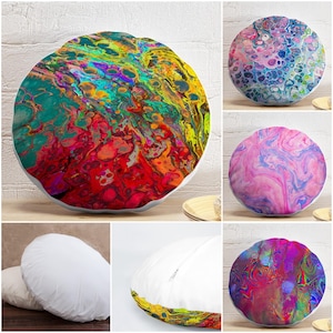 May include: Round decorative pillows with abstract designs. The pillows feature vibrant colors and patterns, including swirls of pink, blue, purple, and yellow. The pillows are round and have a white border. The overall theme is home decor.